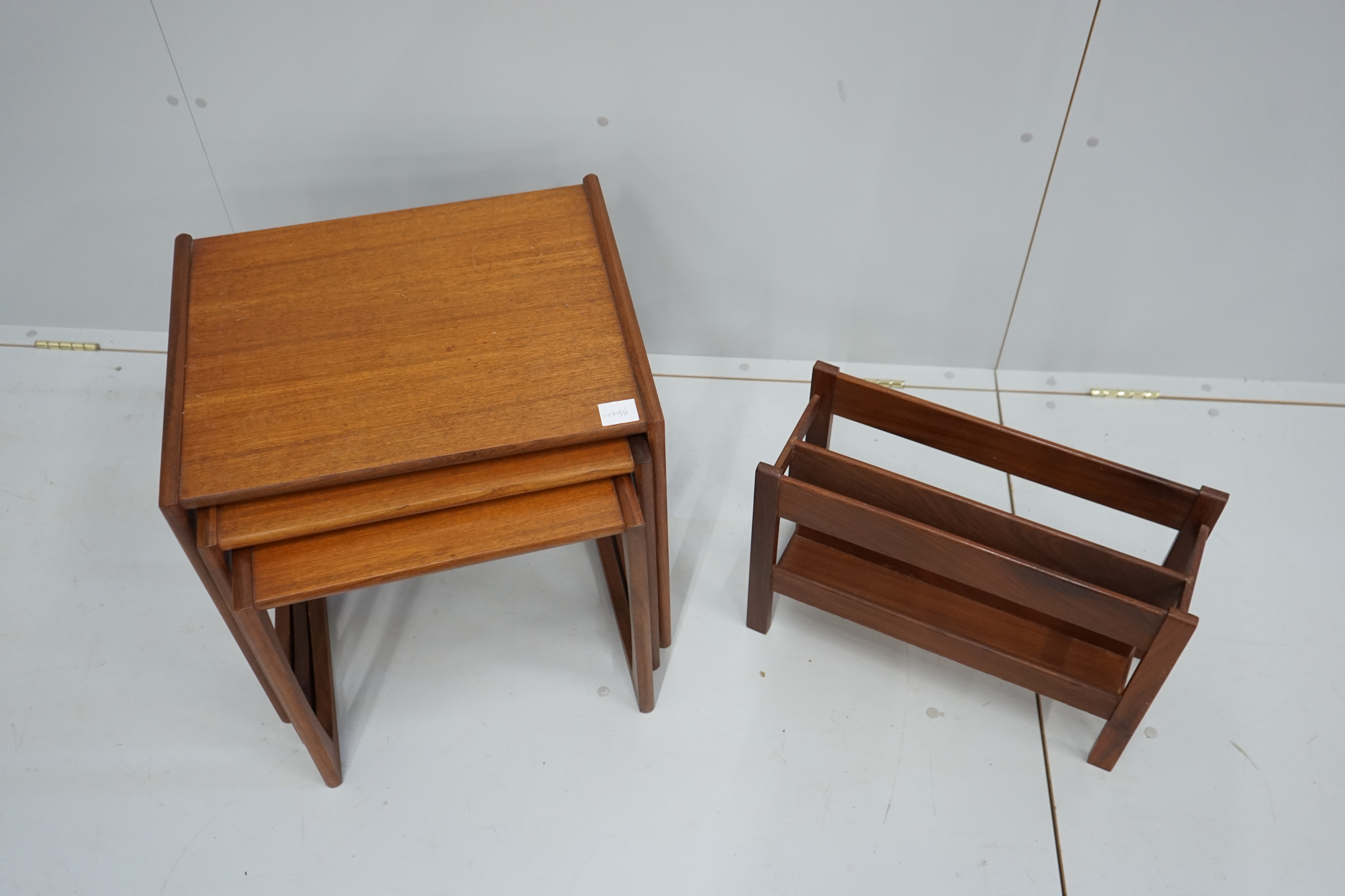 A nest of three G Plan teak tables, width 53cm, depth 43cm, height 49cm together with a two division Canterbury
